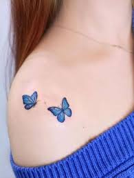 Blue Color Flying Butterfly Tattoo On Shoulder